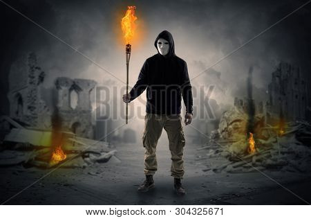 Destroyed place after a catastrophe with man and  burning flambeau concept