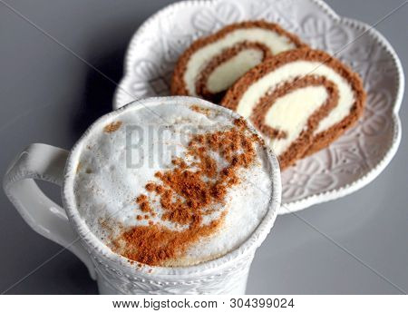 Cappuccino With Cinnamon And Chocolate Swiss Roll.