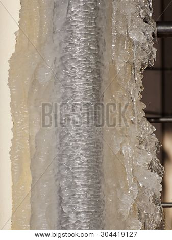 Ice And Icicles On A Drainpipe. Drainpipe Covered With Ice And Icicles.
