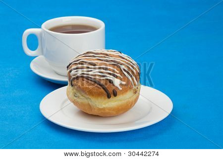 Donut(Doughnut) çikolata ve şeker sır ile kaplı üzüm ile. Fincan çay.