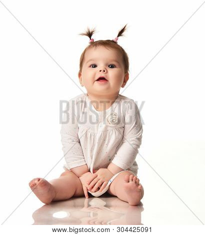 Infant Child Baby Girl In White Dotted Dress Sitting Happy Laughing Smiling Isolated On A White Back