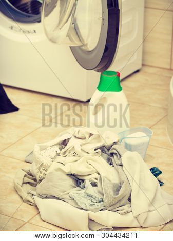 Washing Powder Detergent And Measuring Cup Next To Machine In Bathroom. Household Duties, Clothes La