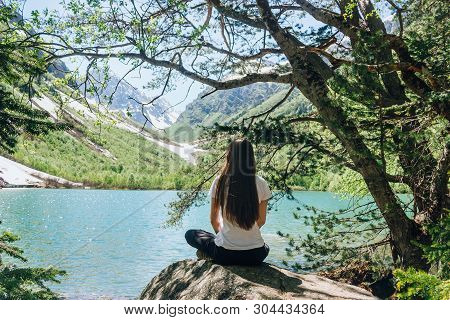 Young Woman Is Practicing Yoga At Mountain Lake. Third Baduk Lake. Dombay, Karachay-cherkess Republi