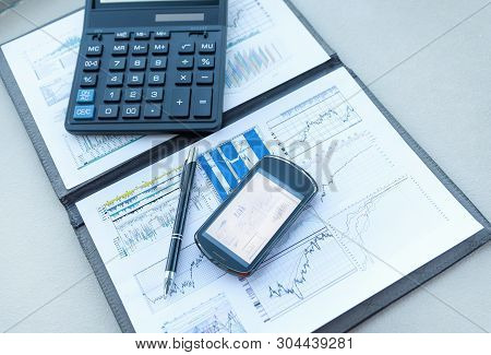 Calculator, Smartphone And Financial Documents On The Businessm