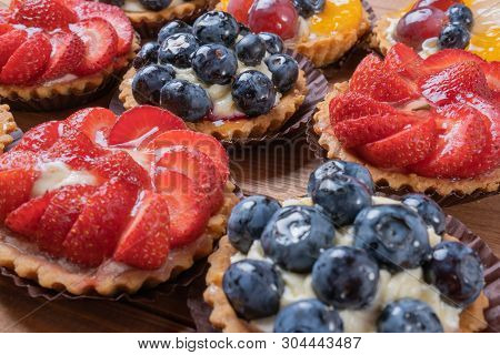 Fruit Tartlets On A Wooden Plate On The Table, Fruit Baked Shell, Fruit Cupcake With Berry