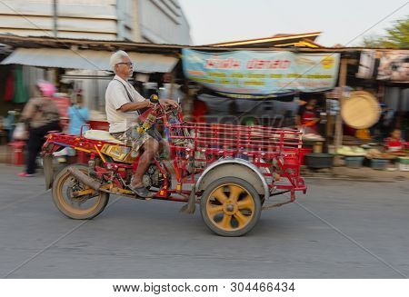 Sukhothai, Tahiland - 2019-03-06 - Old Man Drives His Three Wheeled Motor Cart Through Market.