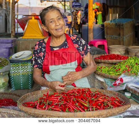 Sukhothai, Tahiland - 2019-03-06 - Jalapeno Vendor Laughs At Market.