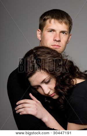 Счастливая молодая пара на сером фоне.