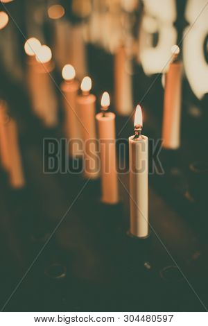 Color Image Of Rows Of Candles Burning In A Church.