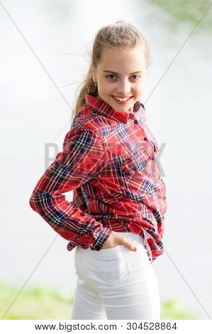A Baby Girl. Adorable Baby With Long Blond Hair Smiling In Casual Plaid Style Outdoor. Happy Little 