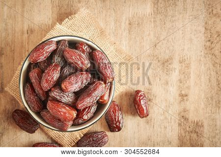 Mock Up Picture Of Dates Palm Fruit In Cup On Wooden Table Background. Dates Palm Fruit Dry Is Snack