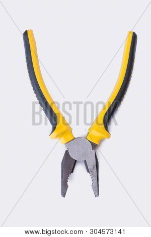 Open Pilers On White Background. Tool With Black And Yellow Handle. Top View With Copy Space.