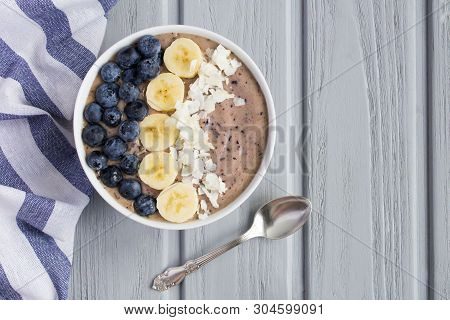 Smoothies Bowl With Blueberry,banana And Coconut Chips On The Grey Wooden Background.top View.copy S