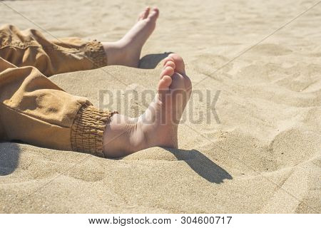 Bare Children's Feet On The Beach. Close-up