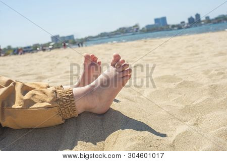 Bare Children's Feet On The Beach. Close-up