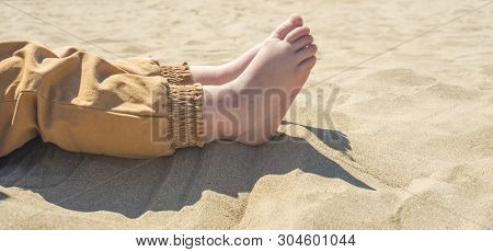 Bare Children's Feet On The Beach. Close-up