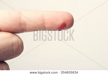 Finger With Drop Of Fresh Blood. Concept Vacine For Healty Lifestyle. Toned Image.