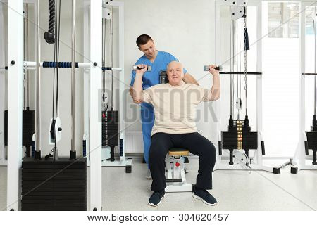 Patient Exercising Under Physiotherapist Supervision In Rehabilitation Center