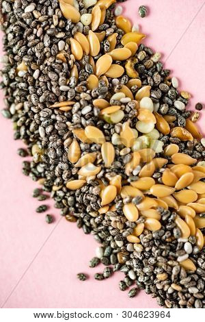 Healthy superfood:  flax seeds, chia seeds and hemp shelled seed on pink background
