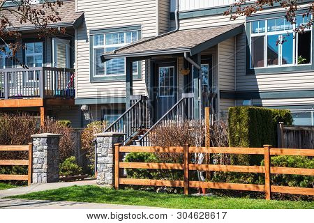 Wooden Front Yard Fence And Entrnace Of Residential Townhouse On Sprint Sunny Day In Vancouver, Cana