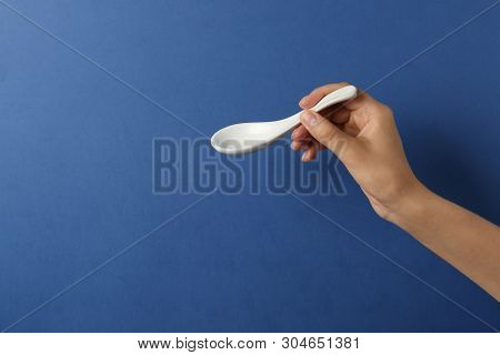 Woman Holding Empty Miso Soup Spoon On Color Background, Closeup. Space For Text