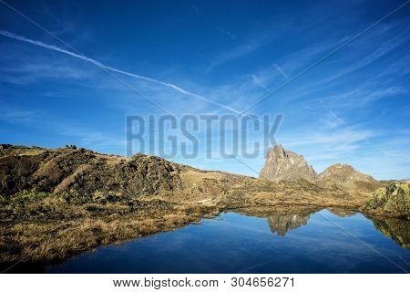 Midi Dossau Peak reflected in a lake. Ossau Valley, Pyrenees National Park, Pyrenees, France.
