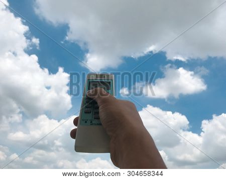 Ha Noi, Viet Nam - 05 2019: Hand Hold Remote Control Directed On The Air Conditioner On Blur Sky Whi