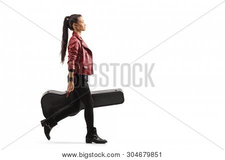 Full length profile shot of a female musician walking and carrying a guitar in a case isolated on white background