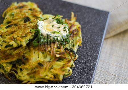 Roesti. Potatoes Grated With Greens, Fried In Butter. Serve On A Stone Board With Sour Cream, Garlic