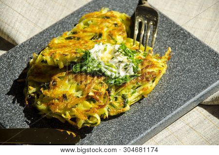 Roesti. Potatoes Grated With Greens, Fried In Butter. Serve On A Stone Board With Sour Cream, Garlic