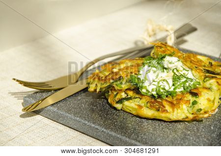 Roesti. Potatoes Grated With Greens, Fried In Butter. Serve On A Stone Board With Sour Cream, Garlic