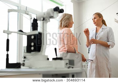 Diligent Long-haired Ophthalmologist Actively Gesturing While Talking