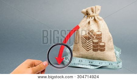 Money Bag With Red Arrow Down. The Concept Of Reducing Profits. Unprofitable Business. Capital Outfl