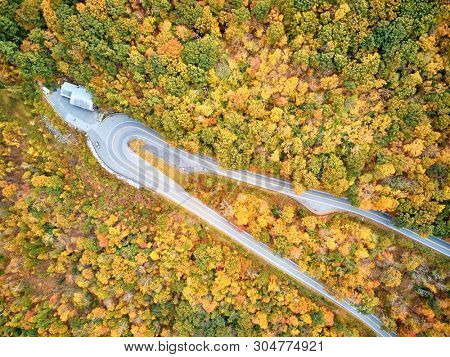 Scenic Mohawk Trail highway hairpin turn in autumn, Massachusetts, USA. Fall in New England. Aerial drone shot. 