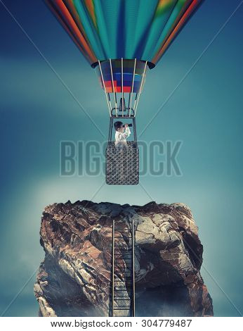 Ladder To The Top Of A Mountain Rock And A Man Looks Through Binoculars Flying With Hot Air Balloon.