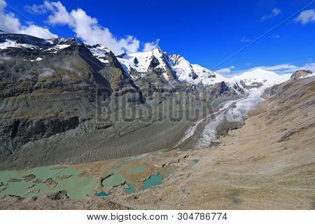 View of Grossglockner, melted snow, moraine and crevasses at Pasterze Glacier, Hohe Tauern National Park in Austria. It is the longest mountain glacier in Austria at approximately 8.4 kms in length