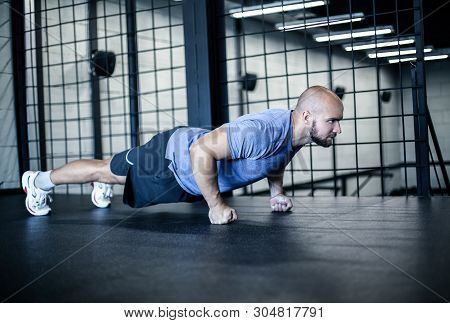 Sport. Young Athletic Man Doing Push-ups. Muscular And Strong Guy Exercising. Dressed In A Sports Un