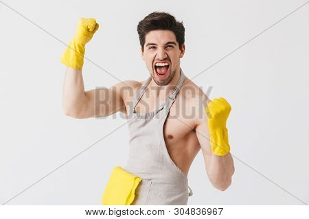 Handsome shirtless brunette houseman wearing apron standing isolated over white background, flexing muscles