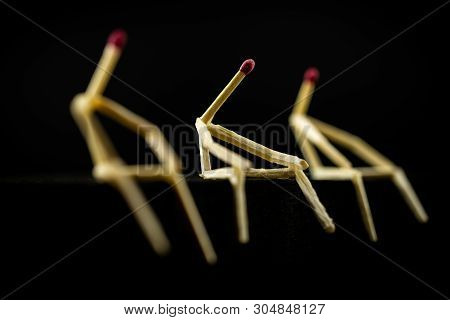 Image Of Three Men With Matchsticks Sitting In The Dark, One Of Them Sad And Erased. Concept Of Lone