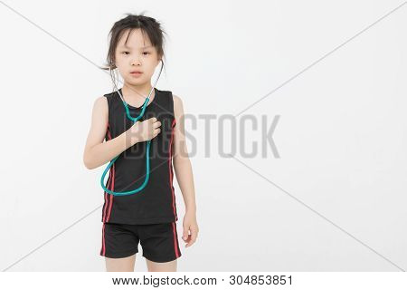 Pretty Asian Girl In Sportswear Wears Green Stechoscope And Posing To Camera, Studio Shot On White B