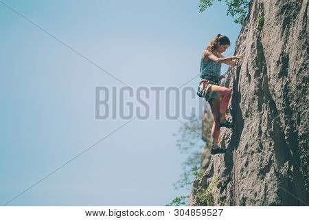 Rock Climbing And Mountaineering In The Paklenica National Park. A Woman Overcomes A Challenging Cli