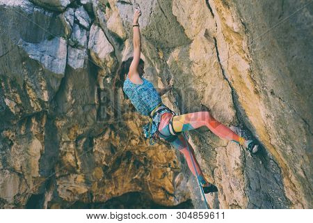 Rock Climbing And Mountaineering In The Paklenica National Park. A Woman Overcomes A Challenging Cli