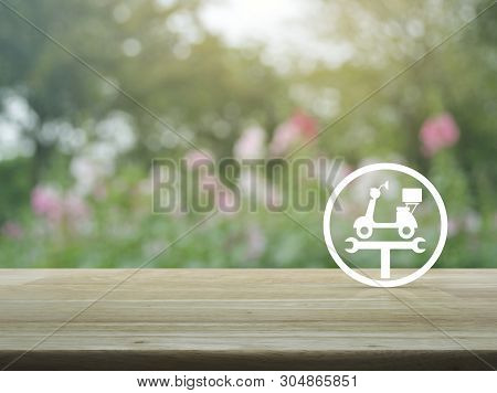 Service Fix Motorcycle With Wrench Tool Flat Icon On Wooden Table Over Blur Pink Flower And Tree In 
