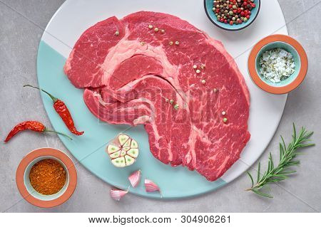 Raw Steak. Meat With Spices And Herbs. Top View On Light Stone Background.