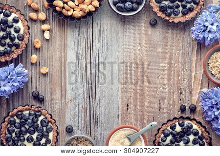 Top View On Wholegrain Blueberry Tarts With Vanilla Cream On Rustic Wooden Background, Copy-space
