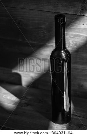 Holidays And Celebration Concept. Wine Bottle In Shadow On Dark Blue Wooden Background. Alcoholic Be