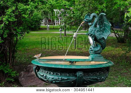 A Sparrow Is Drinking Water From A Fountain In A Form Of Basilisk, Bauman Garden, Moscow, Russia