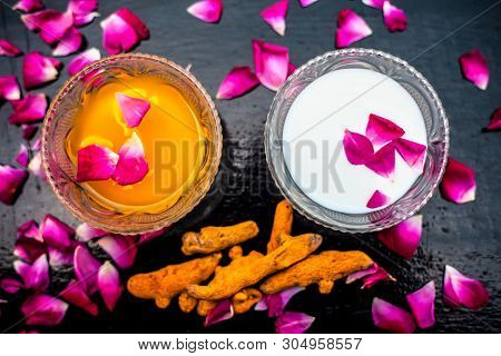 Milk Face Pack On Black Shiny Surface Consisting Of Raw Milk,turmeric Or Haldi And Badam In A Glass