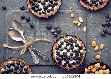 Top View On Wholegrain Blueberry Tarts With Vanilla Cream On Dark Background