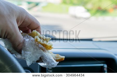 Pie, Belyash With Meat In The Hand Of The Driver In The Car On The Background Of The Steering Wheel 